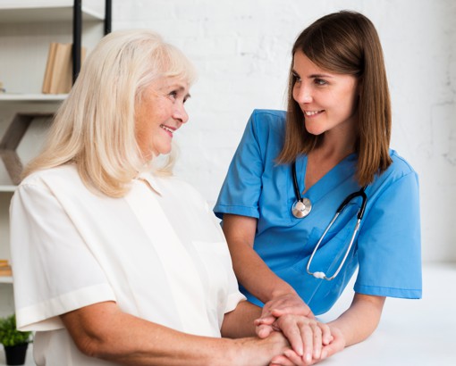 Professional caregiver assisting a senior at home in Portugal